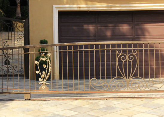 hand made decorative gold tinted sliding gate and hinged pedestrian gate