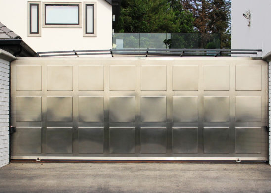 single slide auto gate in contemporary stainless steel with medallions
