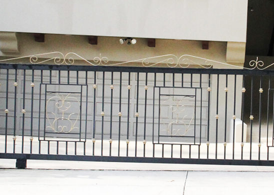 black wrought iron with faux brass accents auto sliding gate