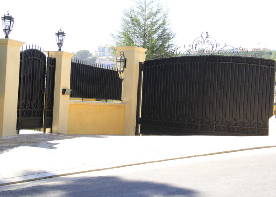 black wrought iron and sheet metal pedestrian and auto gates