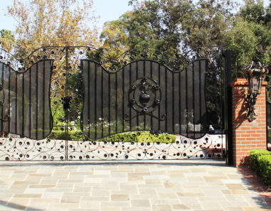 bifold auto wrought iron gate with steel mesh and decorated with handmade flower and leaf appliques