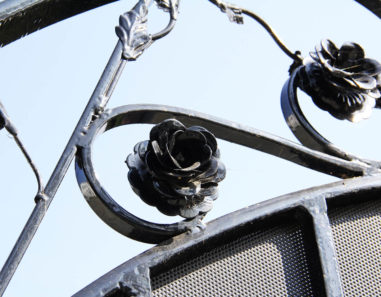 close up of handmade flower and leaf appliques on wrought iron gate
